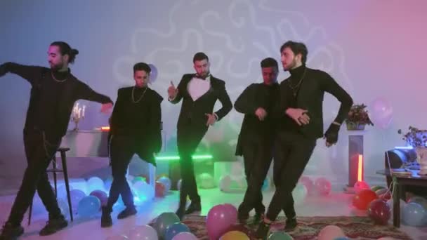 Grupo de jóvenes bailarines modernos bailando, globos de aire multicolores en el suelo, habitación con decoradas con luces de neón de colores — Vídeo de stock