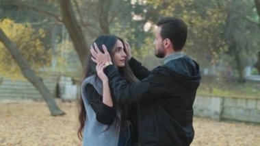 Birbirine aşık çiftler, sonbahar parkında birbirlerinin yüzüne bakarlar.