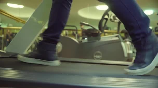 Close-up voeten van de man lopen in snel tempo op loopband in de sportschool — Stockvideo