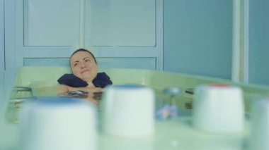 Genç ve çekici bir kadın banyoda yatıyor. Tedavi amaçlı banyo, rahatlama ve iyileşme. Kadınlar için su tedavileri