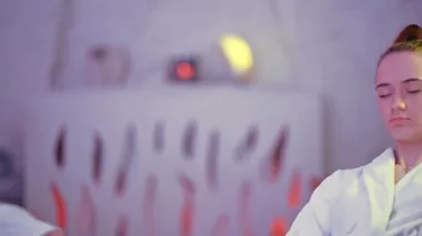 Genç bir kız kaplıcada dinleniyor, beyaz önlüklü.