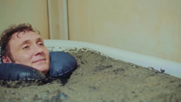 Man lies in a therapeutic mud bath,relaxation,clouse up — Stock Video