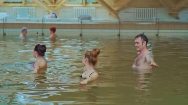 Семья в бассейне занимается водной аквагимнастикой в мастерской в реале — стоковое видео