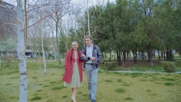 Pareja de mediana edad caminando en el parque, la mujer está vestida de rojo — Vídeos de Stock