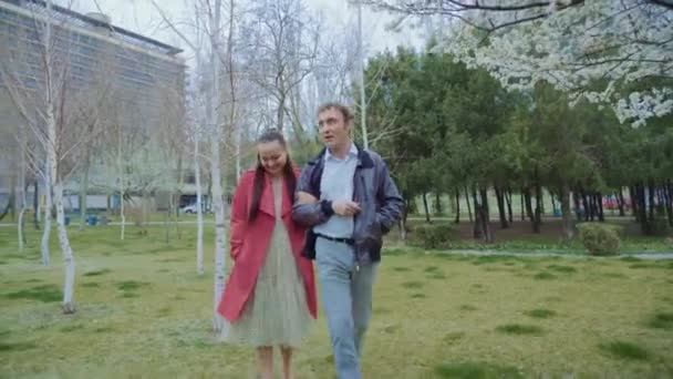 Casal de meia-idade andando no parque, A mulher está vestida de vermelho — Vídeo de Stock