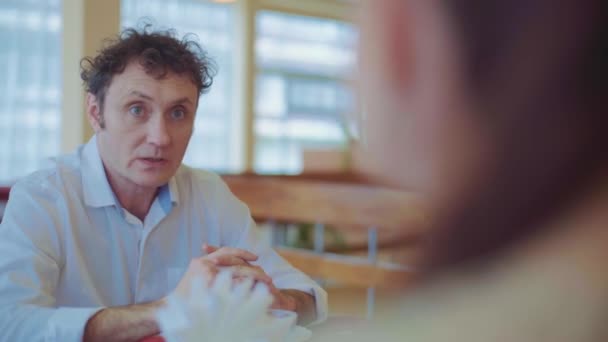 A középkorú férfi az étteremben beszél a családjával. — Stock videók