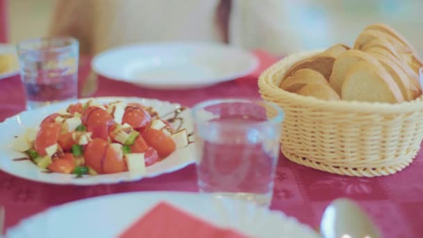 Pan en la mesa, ensalada y platos de carne en un plato — Vídeo de stock
