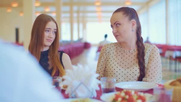 Мати розмовляє зі своєю молодою донькою в ресторані — стокове відео