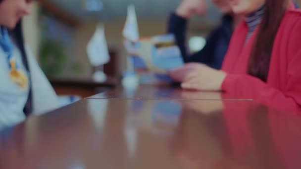 The girl who works at the reception gives the key to the hotel room,The lady in the red dress takes the key — Stock Video