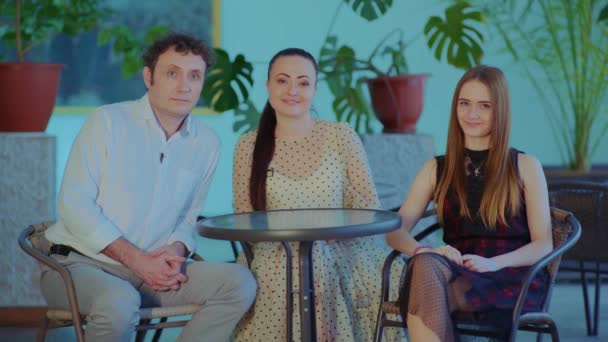 Happy family sits at the table and looks at the camera and talks — Stock Video