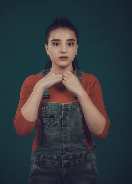 Kırmızı kazaklı ve mavi tulumlu güzel bir manken.,