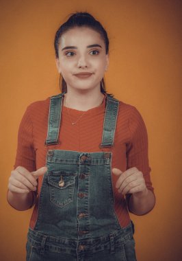 Kırmızı kazaklı ve mavi tulumlu güzel bir manken.,