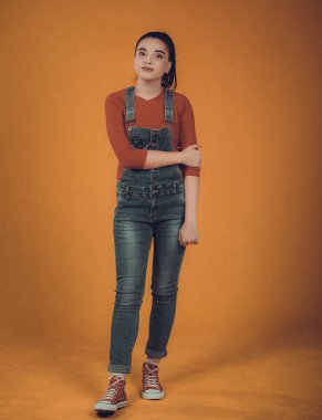 Kırmızı kazaklı ve mavi tulumlu güzel bir manken.,