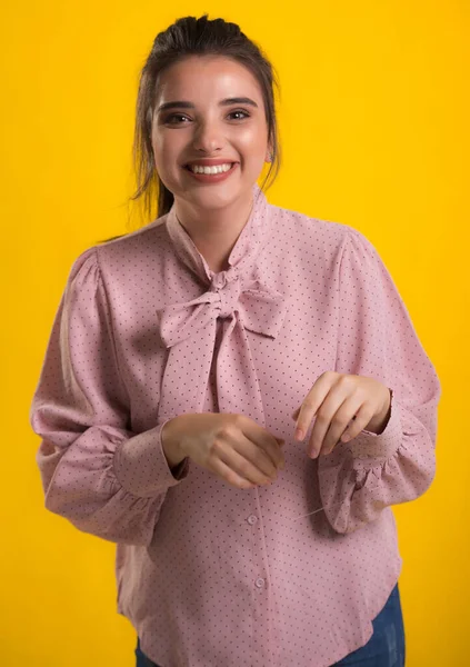 Pembe süveter giyen genç, güzel esmer model, arkasında mavi arka plan, okşama çok tatlı görünüyor, stüdyoda poz veriyor.,
