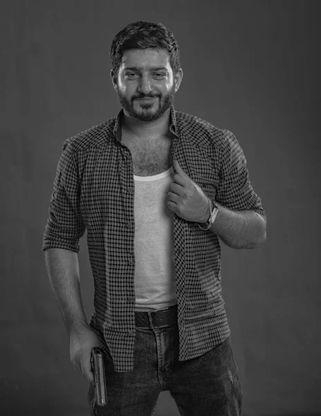 Pembe süveter giyen genç, güzel esmer model, arkasında mavi arka plan, okşama çok tatlı görünüyor, stüdyoda poz veriyor.