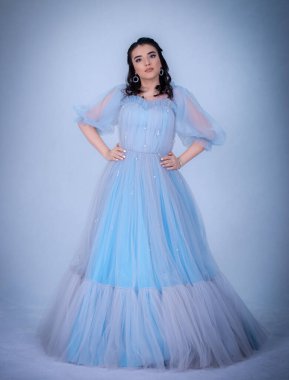 Prenses suretinde genç ve güzel bir manken. Mavi elbiseli bir Sindrella.,