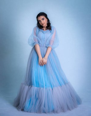 Prenses suretinde genç ve güzel bir manken. Mavi elbiseli bir Sindrella.,