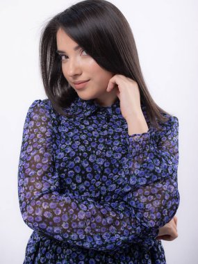 Stüdyoda poz veren mavi elbiseli mutlu güzel kadın beyaz arka planda izole edilmiş, uzun saçlı, kameraya gülümseyen.,