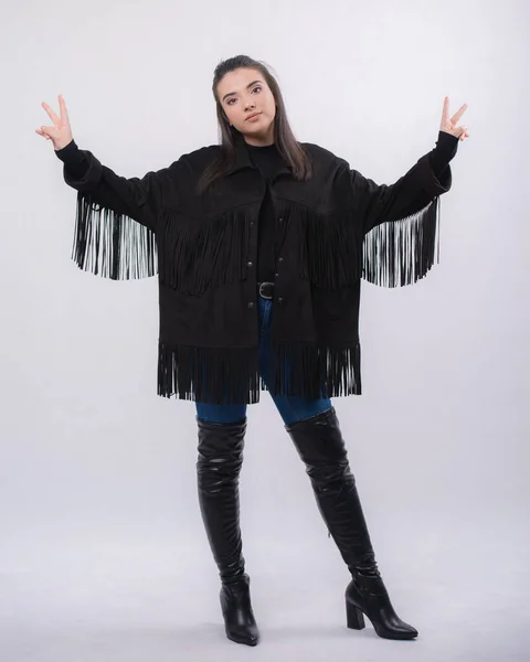 Happy beautiful girl model in black dress posing in studio isolated on white background,Teen girl in in blue jeans and black boots Full length portrait,opened her arms smiling,