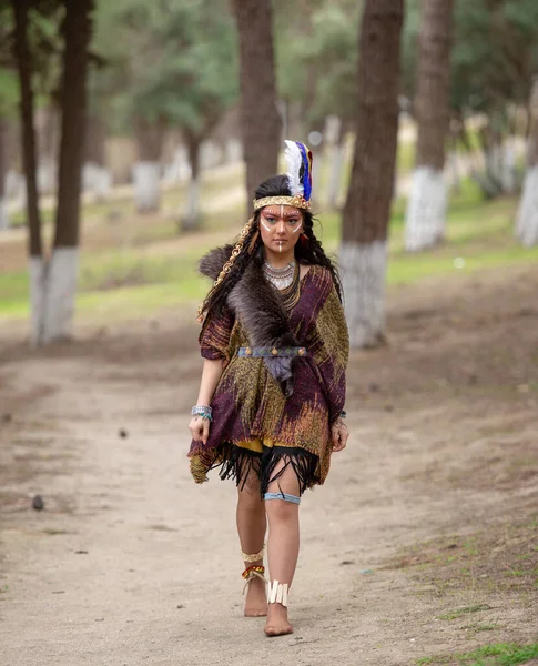 Native American indian woman portrait outdoors,portrait of shamanic female with Indian feather hat and colorful makeup,