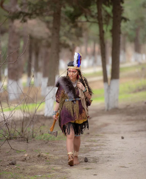Native American indian woman portrait outdoors,portrait of shamanic female with Indian feather hat and colorful makeup,