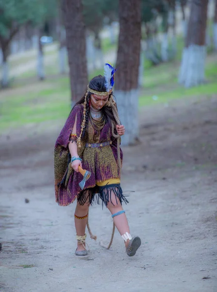 Native American indian woman portrait outdoors,portrait of shamanic female with Indian feather hat and colorful makeup,