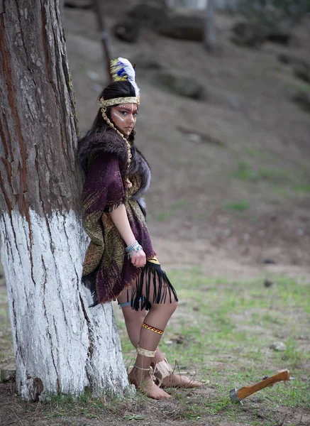 Native American indian woman portrait outdoors,portrait of shamanic female with Indian feather hat and colorful makeup,