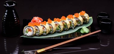 Siyah arka planda suşi yuvarlanıyor.