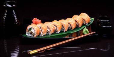 Siyah arka planda suşi yuvarlanıyor.