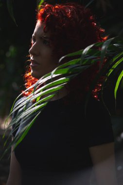 Doğanın ortasında kızıl saçlı çekici bir model.