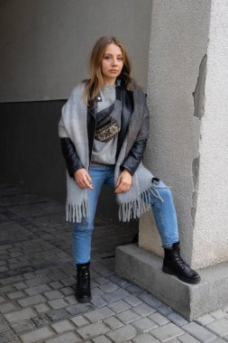 Şehirde poz veren, uzun doğal saçlı şık bir kız. Sokak modası, şehir modası.