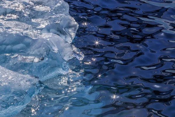 ब्लू आइसबर्ग और सूर्य का ड्रिफ्टिंग टुकड़ा पानी सर्फ पर चमक रहा है — स्टॉक फ़ोटो, इमेज