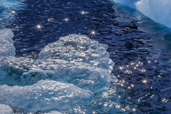Pedazo de iceberg a la deriva en la orilla y las bengalas del sol en el wat —  Fotos de Stock