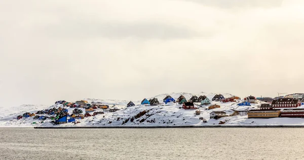 Kleurrijke hutten op de heuvel bedekt met sneeuw, Aasiaat stad panora — Stockfoto