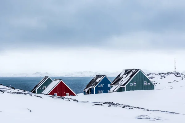 Vier farbenfrohe Inuit-Häuser inmitten von Felsen in einem Vorort der Arktis — Stockfoto