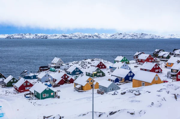 Красочные инуитские домики среди скал и снега на фьорде на подлодке — стоковое фото