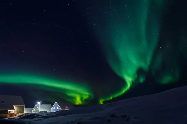 Aldea ártica y olas verdes de auroras boreales en un suburbio de —  Fotos de Stock