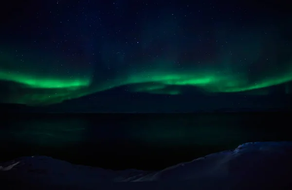 Ondas verdes de Aurora Borealis com estrelas brilhantes sobre o fiorde — Fotografia de Stock