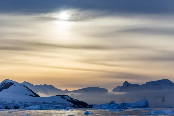 Solnedgång över bergen med glaciärer och drivande isberg på — Stockfoto