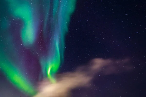 Verde auroras boreales que brillan en el cielo entre las estrellas y el clo —  Fotos de Stock