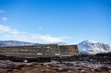 Yosunlu taşlarla gerginim beyaz dik yamaçları arasında Eskimo evleri