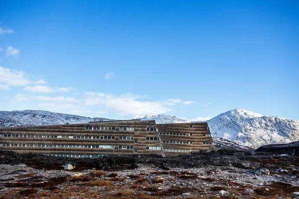 Yosunlu taşlarla gerginim beyaz dik yamaçları arasında Eskimo evleri