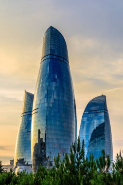 Üç alev gökdelen günbatımı üzerinde ve şehir merkezinde kuleleri,
