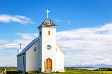 Flateyjarkirkja beyaz lutheran Kilisesi ile çayır ön planda 
