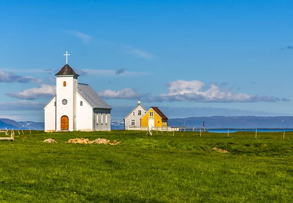 Flateyjarkirkja witte Lutherse kerk en paar van levende hutten Stockfoto