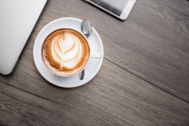 Masada iş aletleri olan bir fincan kahve, dinlenme zamanı..