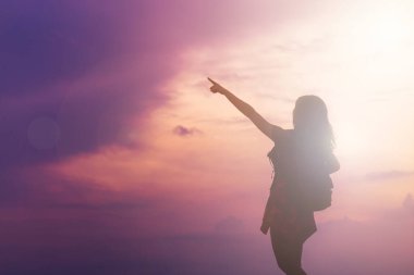 Sırt çantası taşıyan genç mutlu Asyalı kadınlar gün batımında gökyüzü ile birlikte dışarı seyahat ediyorlar..