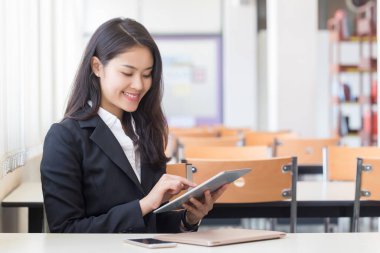 Ofiste ticari teknoloji cihazı kullanan genç bir iş kadını..