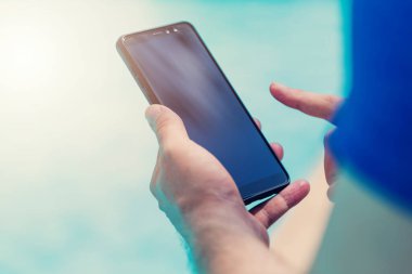 Havuz kenarındaki akıllı telefonu tutarak elinizi kapatın..