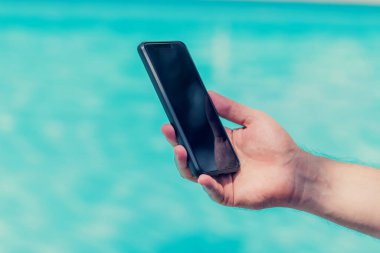 Havuz kenarındaki akıllı telefonu tutarak elinizi kapatın..